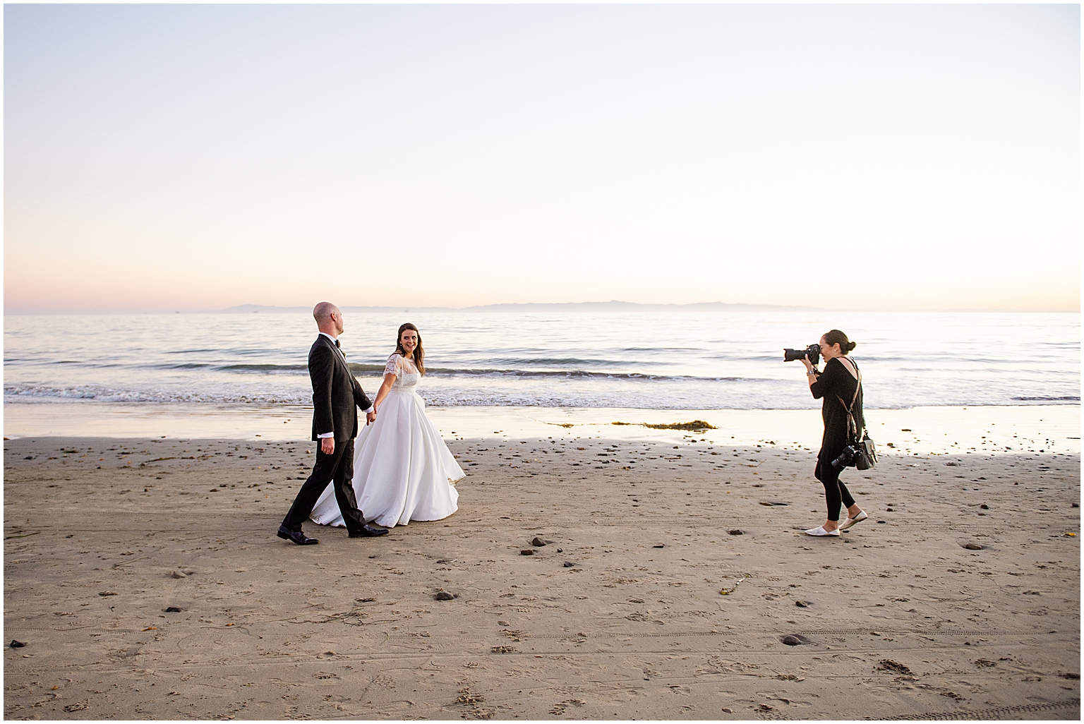 wedding photographer taking photos of bride and groom, bride and groom on the beach