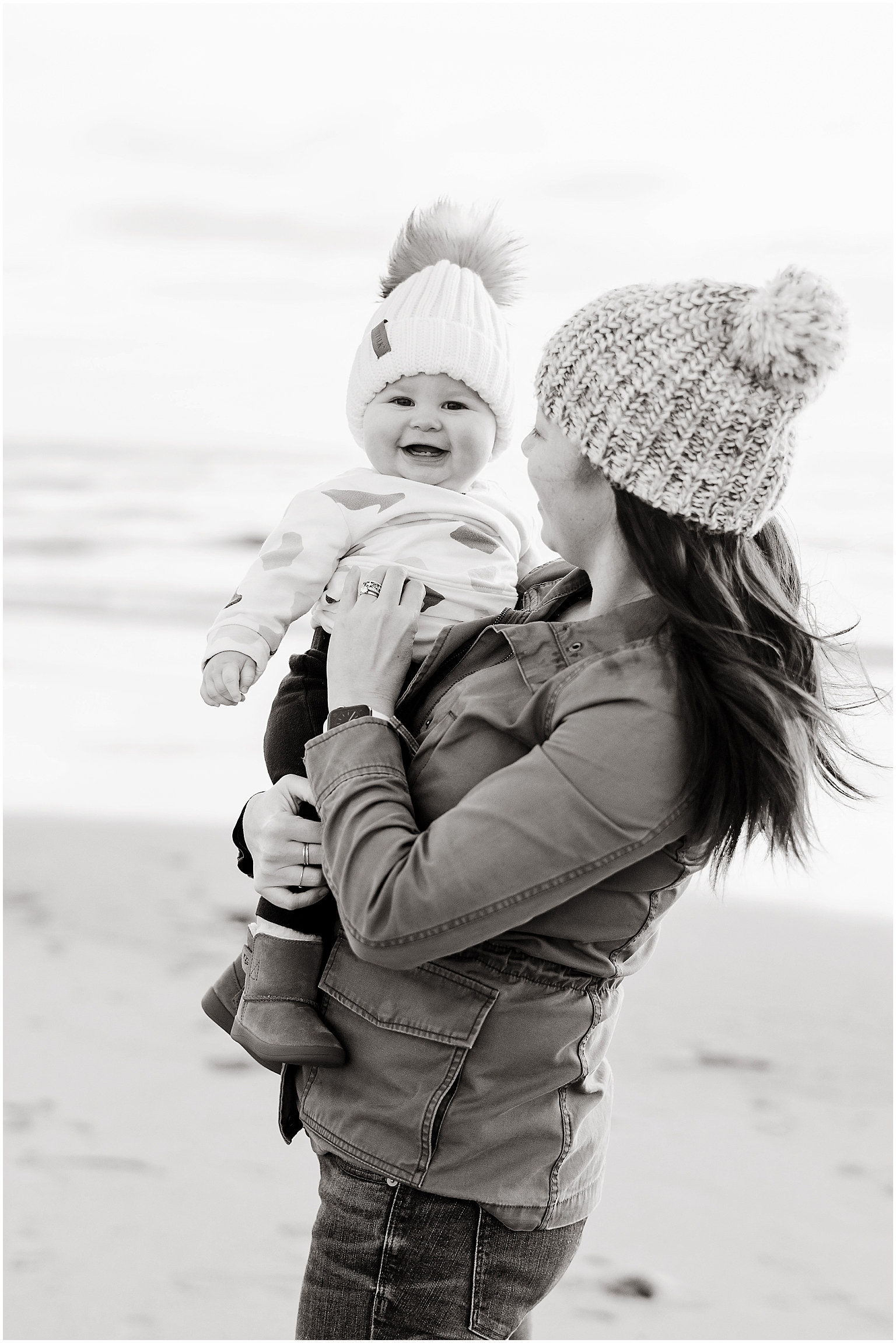 mom and baby in beanies on the beach